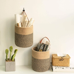 Detail of woven jute storage baskets with leather handles and two-tone texture