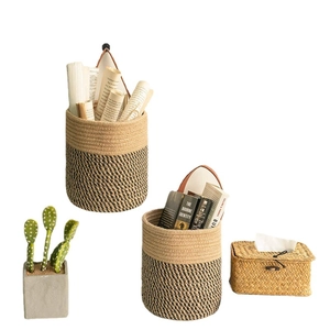 Hanging woven plant baskets in two-tone neutral colors with brown leather handles