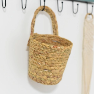 Detail of handwoven seagrass wall basket featuring natural texture and round handle