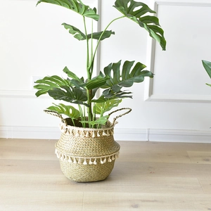 Handmade woven seagrass basket with decorative white tassels and sturdy carry handles