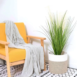 Close-up of a woven cotton rope plant basket with a decorative grey knitted waffle blanket