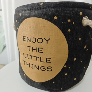 Detail of grey linen storage pot featuring yellow moon print and thick rope handles