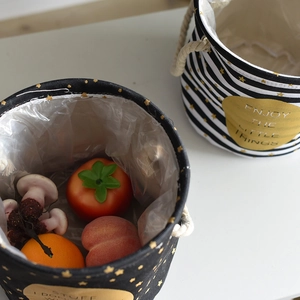 Detail of linen storage baskets with star prints, cotton rope handles, and waterproof lining