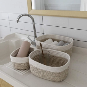 Three-piece set of woven cotton rope baskets in white and grey for bathroom storage