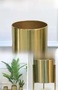 Detail view of gold electroplated cylindrical metal planters with matching iron stands