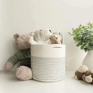 Handwoven cotton rope storage basket in white and grey with dual handles and plush toys