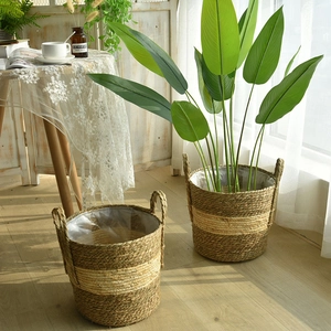 Close-up of woven straw plant pot cover with waterproof liner and dual handles