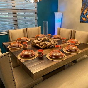 Handwoven natural seagrass placemat set on wooden dining table with bohemian ceramic dinnerware