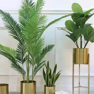 Modern gold iron planters with tropical faux plants on tall metal stands for home decor