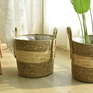 Detail of woven straw plant pot with dual handles and waterproof liner for home storage