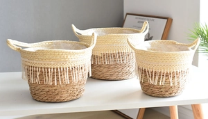 Three-piece set of woven seagrass baskets with white fringe and handles for home decor