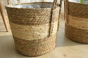 Detail of woven straw plant basket with plastic lining and bicolor natural sea grass texture