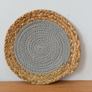 Détail du set de table rond fait main avec paille naturelle et coton gris tissé