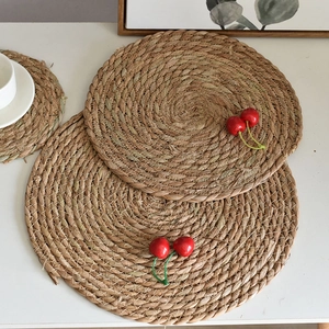 Detail of round woven seagrass coasters and placemats set in a bright kitchen scene