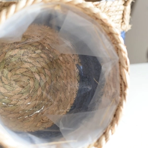 Close-up of handwoven seagrass plant basket showing the waterproof plastic inner liner
