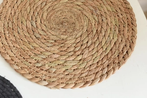 Detail of hand-woven natural seagrass round coaster with spiral texture and rustic design