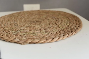 Macro shot of natural seagrass woven coaster showing thick braided edges and durable texture