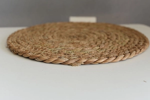 Detailed close-up of natural seagrass woven round coaster showing intricate fiber texture