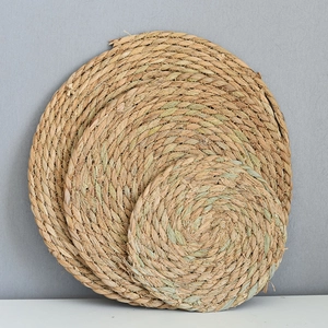 Three sizes of natural seagrass woven coasters in a stack showing rustic texture