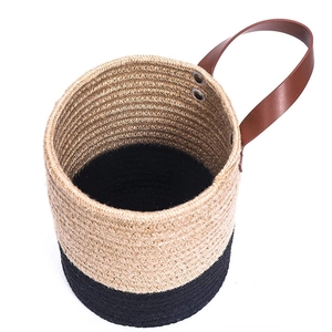 Detail view of cotton rope woven basket with brown leather handle and metal rivets