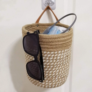 Detail of woven cotton rope hanging basket with brown leather handle and storage use
