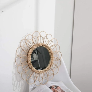 Detailed view of hand-woven rattan wall mirror featuring a decorative flower-shaped design