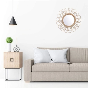 Detail of hand-woven natural rattan wall mirror with a creative sunburst floral frame design