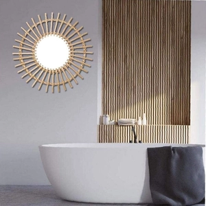 Detail of sunflower shaped wall mirror with hand-woven bamboo frame in minimalist bathroom