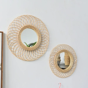 Detail of handcrafted rattan wall mirror with intricate woven spiral pattern on the frame