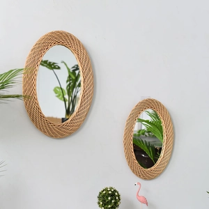 Detail of oval woven rattan wall mirrors in a bohemian style on a grey wall decoration