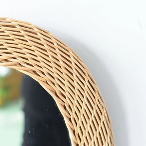 Detailed view of hand-woven natural rattan texture on circular wall mirror frame
