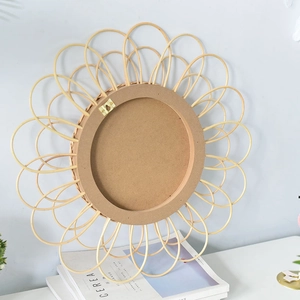 Detail view of the back of a woven rattan wall mirror with a gold metal hanging hook