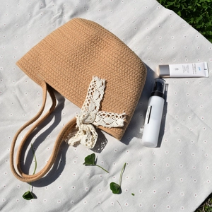 Handwoven straw tote bag with lace bow decoration for summer beach and vacation