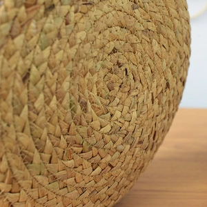 Macro shot of handwoven round storage basket showing natural straw fiber texture and weave