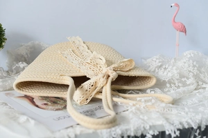 Detailed view of beige woven straw tote bag with elegant white lace bow decoration