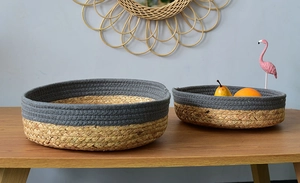 Close-up of dual-tone round woven storage baskets in gray and natural seagrass texture