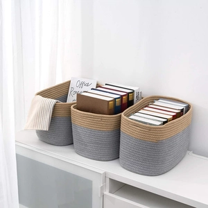Detail of three cotton rope woven storage baskets in khaki and gray patchwork design
