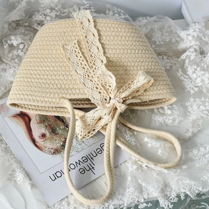 Detailed texture of beige woven straw tote bag with elegant white lace bow decoration