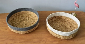 Detail of round handmade grass woven baskets with gray and white cotton rim accents