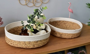 Detail of woven straw storage baskets with white cotton accents in home setting