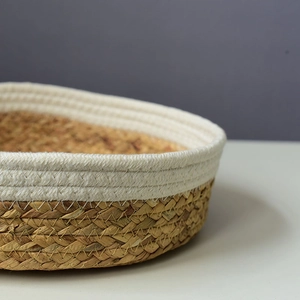 Detailed close-up of woven seagrass basket with white cotton rope edge and stitching