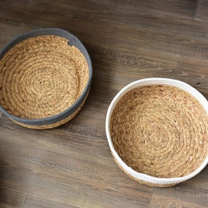 Detail view of handmade woven storage baskets with gray and white rope edges
