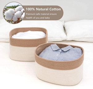 Detailed view of dual-tone rectangular cotton rope storage baskets on a cozy bed