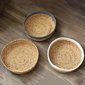 Handwoven round seagrass storage baskets in natural, grey, and white color styles