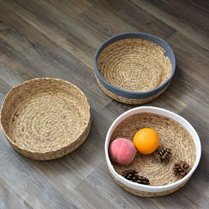 Detailed view of three circular hand-woven seagrass baskets in various color patterns