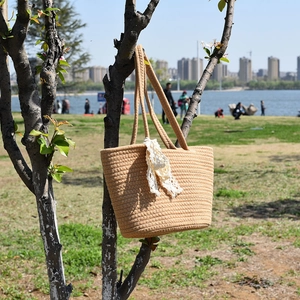 Handwoven khaki straw shoulder bag with white lace ribbon detail for beach vacations