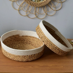 Detail of two-piece round woven storage baskets made from natural grass and white cotton