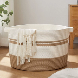 Detail of woven cotton rope laundry basket featuring bicolor stitching and handles