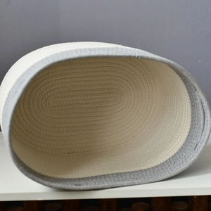 Close-up of woven cotton rope storage basket in minimalist beige and grey patchwork design