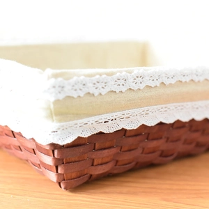 Close-up of a rustic woven storage basket with white lace edges and cotton linen lining